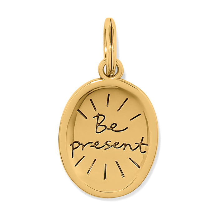 Brighton oval charm with gold-plated finish and engraved "Be present" script with sunburst rays on a white background