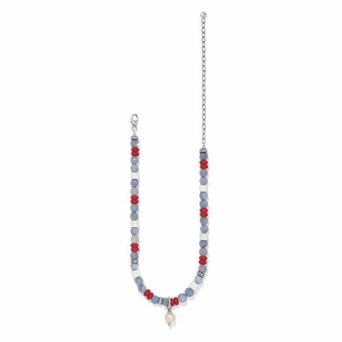Brighton beaded necklace with blue, white, and red beads, pearl drop, and silver-plated chain on a white background