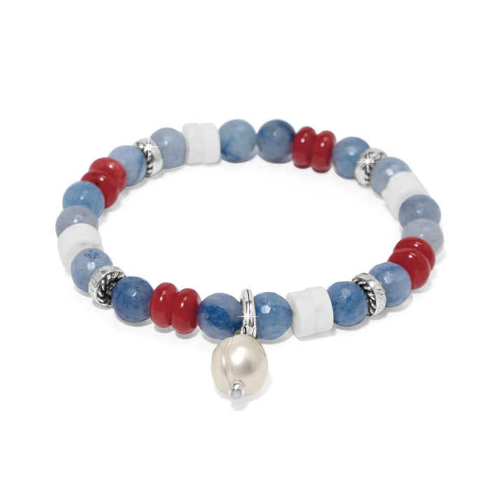 Brighton beaded bracelet with blue, red, and white stones, silver-plated accents, and pearl charm on a white background