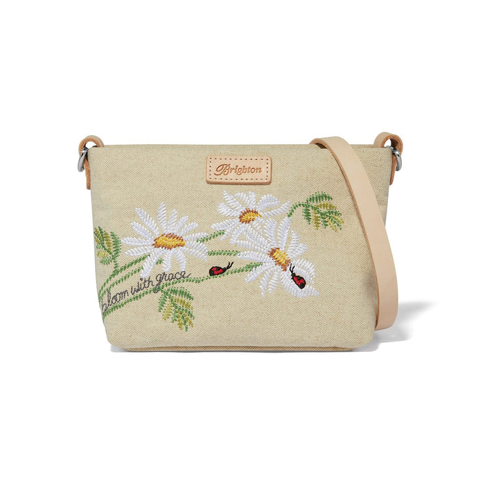 Brighton crossbody handbag in beige canvas with embroidered daisies, ladybugs, and leather strap on a white background