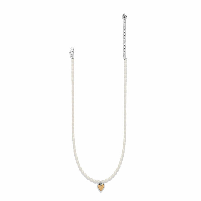 Brighton necklace with rice pearls, two-tone silver chain, and small gold heart pendant on a white background