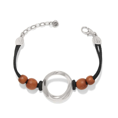 Brighton bracelet with silver-plated open circle centerpiece, wood beads, and black cord with adjustable chain on a white background