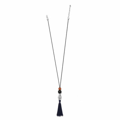 Brighton pendant necklace with wood beads, silver-plated accent, and navy nylon tassel on cord on a white background