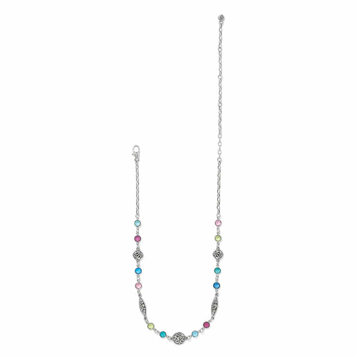 Brighton silver-plated necklace with multicolored crystal stations and ornate scroll medallions on a white background