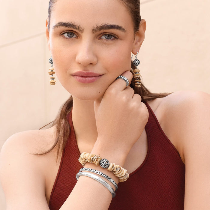 Model wearing Brighton drop earrings with disk beads and silver-plated ornate spheres, with coordinating Brighton accessories