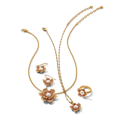 Brighton gold-plated jewelry set with floral pendants, glass pearl cabochons, and pink crystal accents on a white background