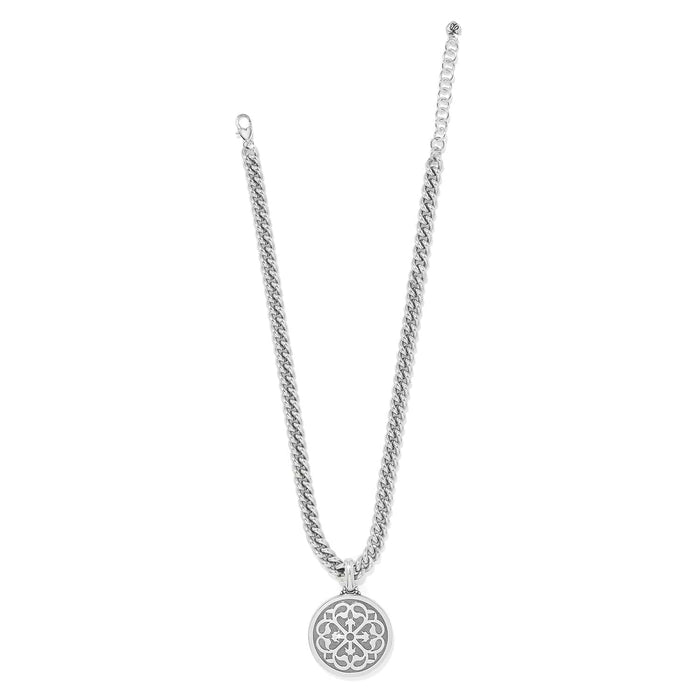 Brighton pendant necklace with silver-plated curb chain and round openwork medallion with scroll design on a white background