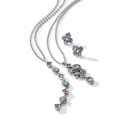 Brighton silver-plated necklaces and earrings styled together with multicolor crystal accents in geometric shapes on white background