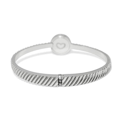 Brighton bangle bracelet with silver-plated ribbed texture and round charm featuring engraved heart detail on a white background