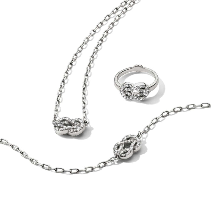 Brighton silver-plated jewelry set with crystal knot motif necklace, bracelet, and ring on a white background