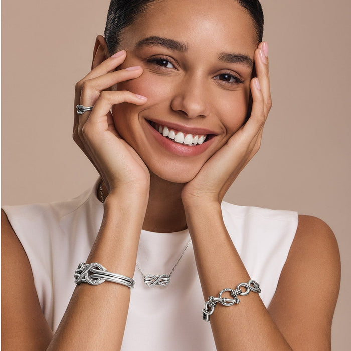 Model wearing a Brighton silver-plated crystal pendant necklace with coordinating Brighton bracelets and ring accessories