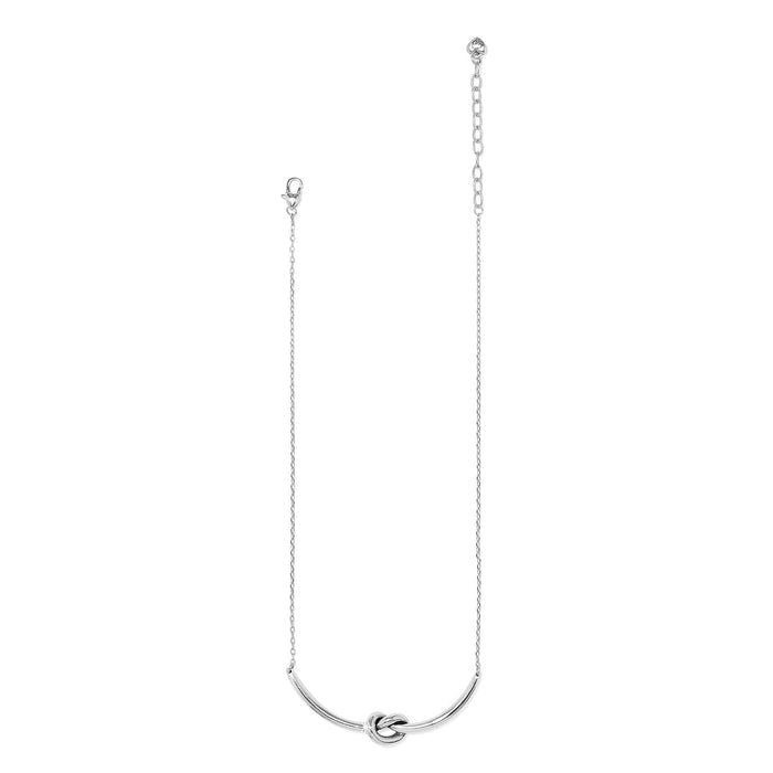 Brighton necklace with silver-plated curved knot pendant, delicate chain, and lobster clasp on a white background