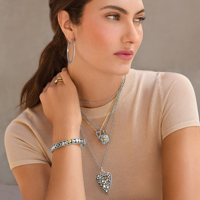 Model wearing Brighton two-tone heart pendant necklaces with crystal accents and coordinating Brighton accessories