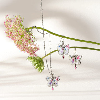 Brighton silver-plated butterfly necklace and earrings styled with pink flowers, featuring enamel floral wings and crystal accents