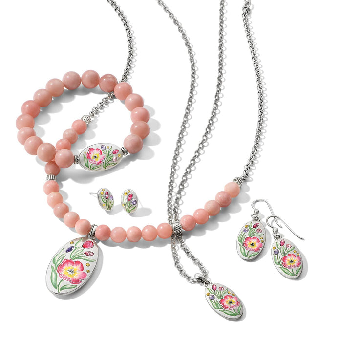 Brighton silver-plated jewelry set styled with pink beaded bracelets and floral enamel pendants featuring crystal accents on white background