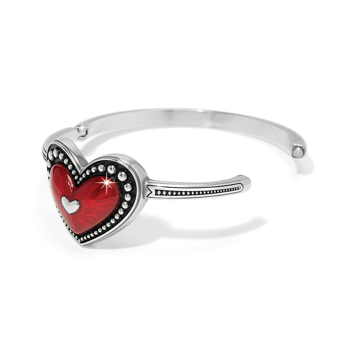 Brighton bangle bracelet with red enamel heart, beaded silver-plated frame, and small heart cutout on a white background