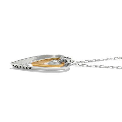 Brighton pendant necklace side view with two-tone heart design, crystal accents, and engraved Calm on a white background