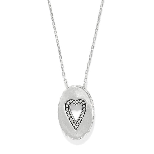 Brighton pendant necklace with silver-plated oval medallion featuring cut-out heart outlined in crystals on a white background