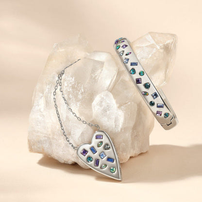 Brighton silver-plated heart pendant necklace and crystal bangle bracelet styled with a quartz crystal on neutral background