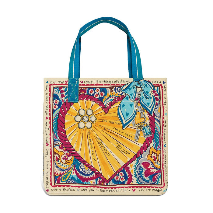 Brighton tote handbag with colorful heart and paisley print, love phrases border, and blue handles on a white background