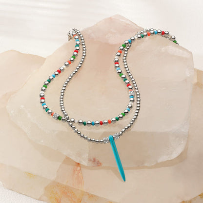 Brighton beaded necklace with silver-plated beads, blue howlite turquoise spike pendant, and multicolor accents styled on quartz stones