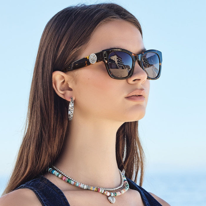 Model wearing Brighton tortoise sunglasses with silver-plated scroll medallion accent and coordinating Brighton accessories