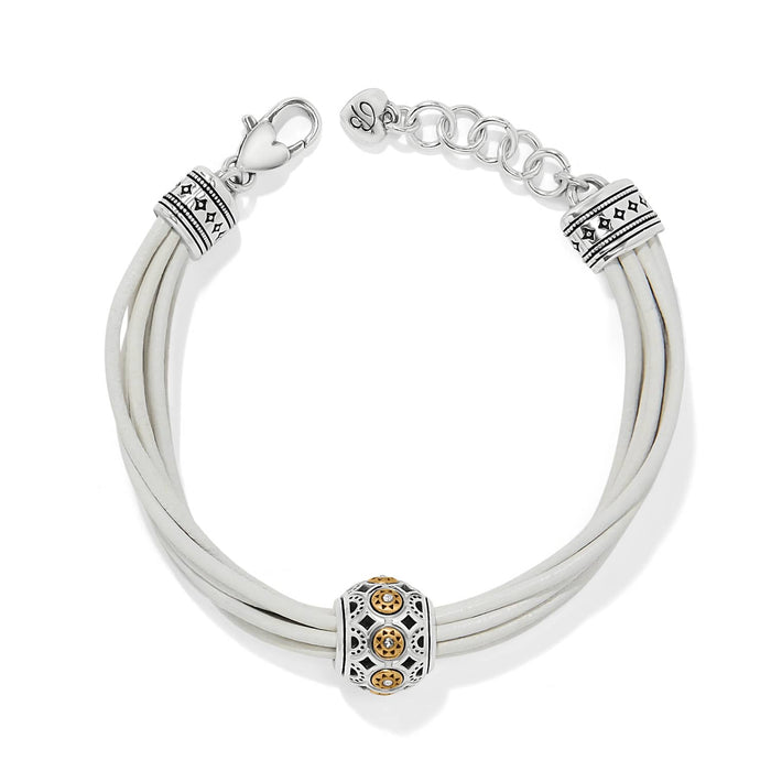 Brighton bracelet with white leather cords, two-tone decorative bead, and silver-tone clasp on a white background