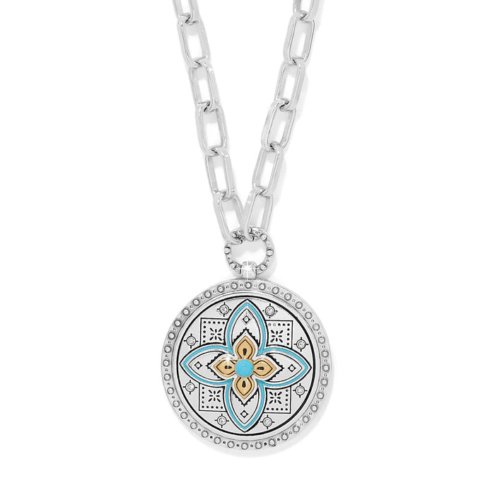 Brighton pendant necklace with two-tone medallion, turquoise enamel floral motif, crystals, and silver-tone chain on a white background