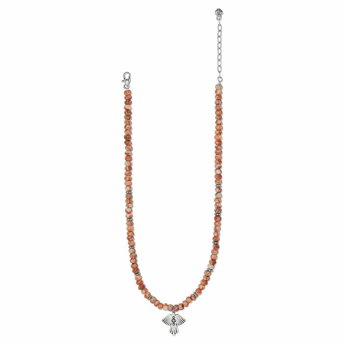 Brighton beaded necklace with orange marbled beads, silver-plated spacers, and thunderbird pendant on a white background