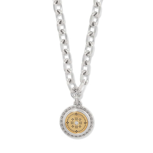 Brighton pendant necklace with two-tone medallion, gold patterned center, crystal accent, and silver chain on a white background