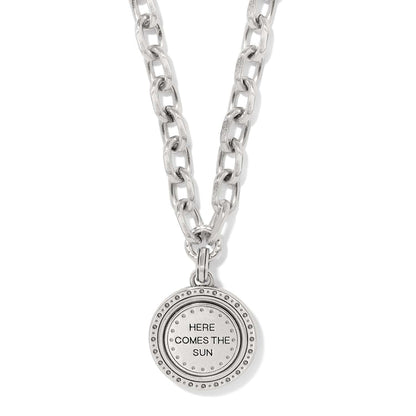 Brighton pendant necklace with chunky silver-tone chain and round medallion engraved Here Comes The Sun on a white background