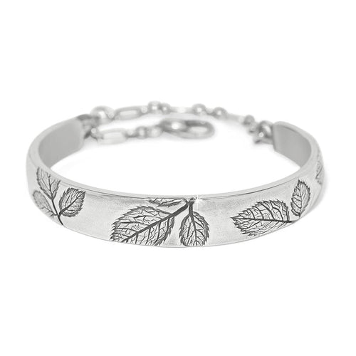 Brighton bangle bracelet with silver-plated finish, embossed leaf designs, and adjustable chain closure on a white background