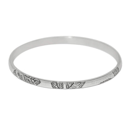 Brighton bangle bracelet with silver-plated finish and engraved tree branch design along the band on a white background