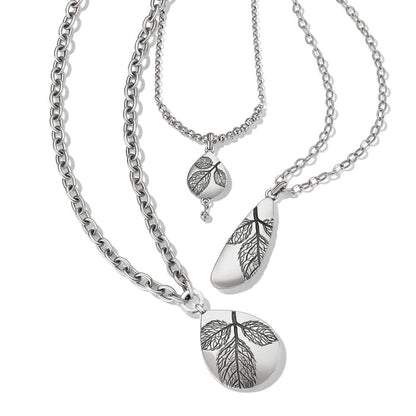 Brighton layered necklace with three silver-plated chains and teardrop pendants featuring engraved leaf designs on a white background