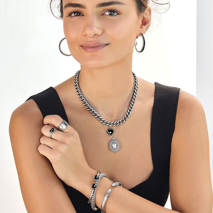 Model wearing a Brighton silver-plated layered chain necklace with heart and oval crystal pendants and coordinating Brighton accessories