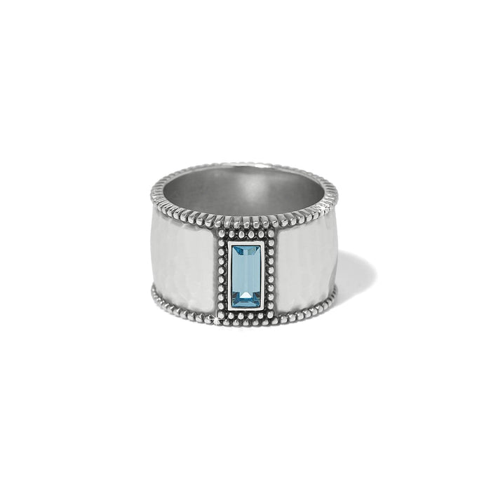 Brighton silver-plated wide band ring with hammered finish, beaded edges, and blue crystal baguette on a white background