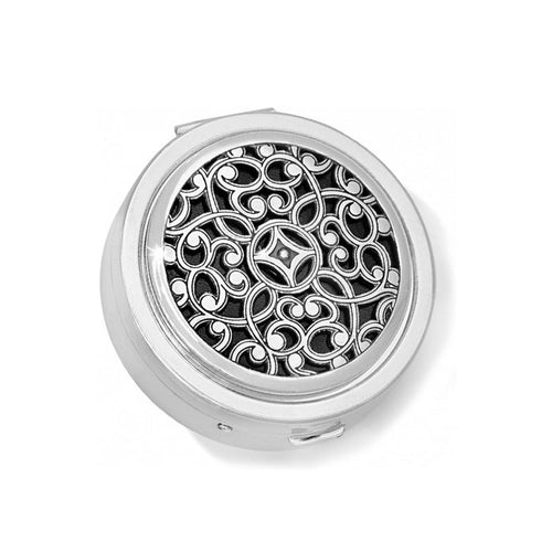 Brighton round pill box with silver-tone scrollwork filigree design over black inlay on a white background