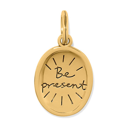 Brighton oval charm with gold-plated finish and engraved "Be present" script with sunburst rays on a white background