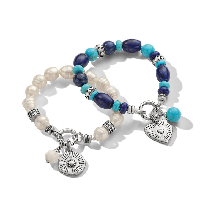 Brighton beaded bracelets with lapis lazuli, turquoise, white pearls, and silver-plated heart and sunburst charms on a white background