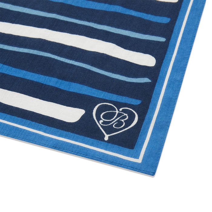Close-up of Brighton scarf corner with navy and white striped print, blue border, and heart logo detail